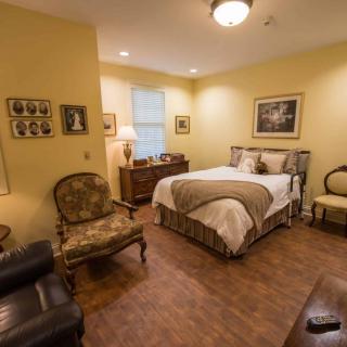 A cozy, traditionally styled bedroom with yellow walls and elegant furniture.