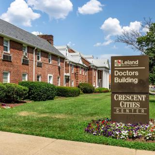 A brick healthcare facility with prominent signage and well-maintained landscaping.