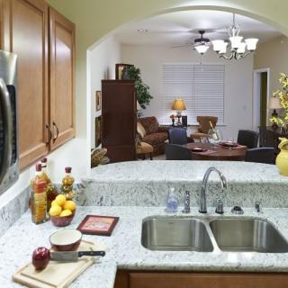 A view from the kitchen featuring a granite countertop with a sink, overlooking the living room area.