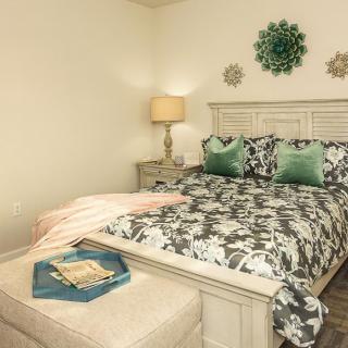 A cozy bedroom with patterned bedding, decorative pillows, and soft lighting.