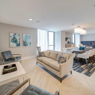 A modern living room with elegant furniture and a dining area, showcasing contemporary interior design.