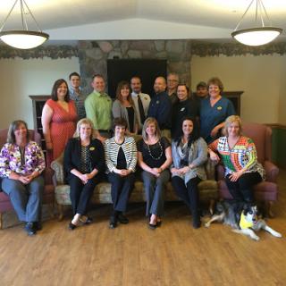 A cheerful team gathered together for a group photo in a cozy indoor setting.