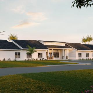 A large suburban house with a landscaped front yard at sunset.
