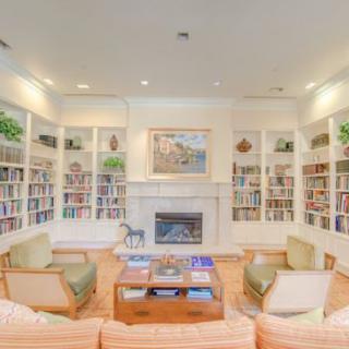 A cozy living room with bookshelves and a fireplace, perfect for reading and relaxation.