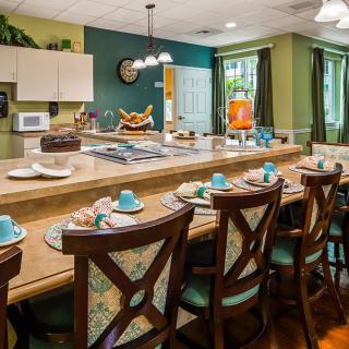 A cozy kitchen with bar seating and a well-set dining area.
