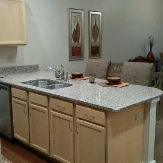 A modern kitchen with a granite countertop and dining setup.