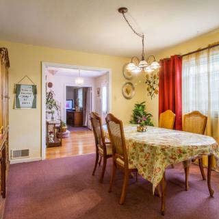 A cozy dining room with a floral tablecloth and a classic chandelier.