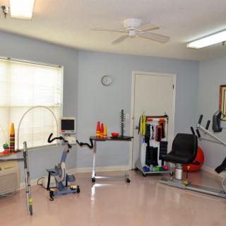 A well-equipped physical therapy room featuring various exercise machines and rehabilitation tools.