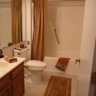 A well-organized bathroom with a bathtub, toilet, sink, and mirror.