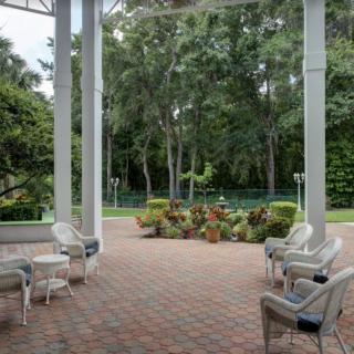 A serene patio with outdoor seating overlooking a lush garden.