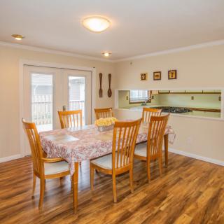 A cozy dining room with a wooden floor and a large dining table surrounded by chairs.