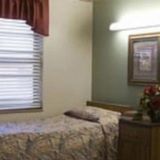 A cozy bedroom with a single bed, window, and wall painting.