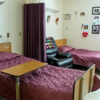 A shared hospital room with two beds and a curtain divider.