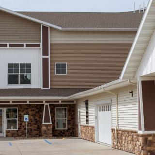 A modern residential building with a mix of stone and siding exterior.