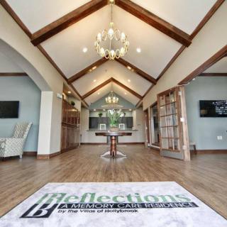 A spacious interior with vaulted ceilings, featuring wooden beams and an elegant chandelier.