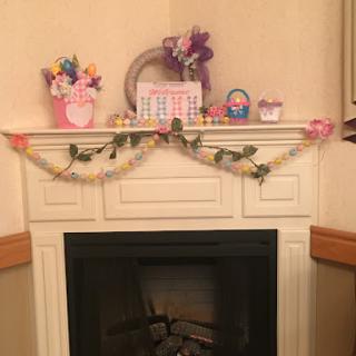 A beautifully decorated fireplace mantel adorned with spring flowers and Easter-themed accessories.
