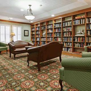 A comfortable library with ample seating and bookshelves lining the walls.