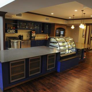 A cozy cafe interior featuring a counter with display cases and warm lighting.