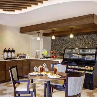 A cozy cafe interior with modern furnishings and a neatly set dining table.