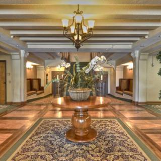 Elegantly decorated lobby with a central plant arrangement and chandelier lighting.