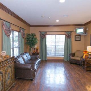 A cozy living room with a sofa, armchair, and wooden flooring.