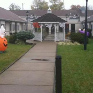 A festive gazebo decorated with Halloween-themed inflatables and decor along a pathway.