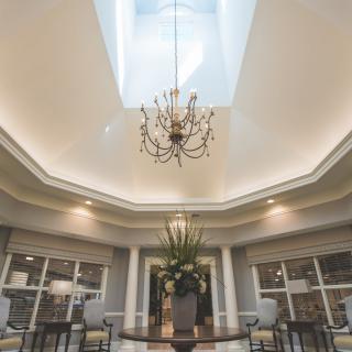 Luxurious dining area with a central skylight and elegant chandelier.