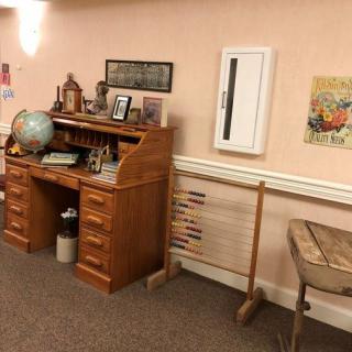 A vintage-themed room with an old wooden desk, globe, and typewriter.