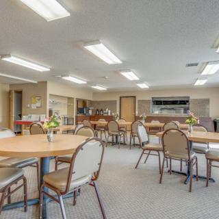 A spacious dining area with multiple tables and chairs, well-lit with overhead lights.