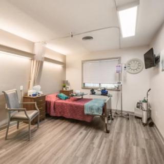 A modern hospital room with medical equipment and a single bed.