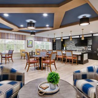 A modern and cozy lounge area featuring comfortable seating, a stylish kitchen, and elegant lighting.