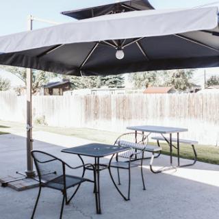 A peaceful outdoor seating area with a large umbrella providing shade.