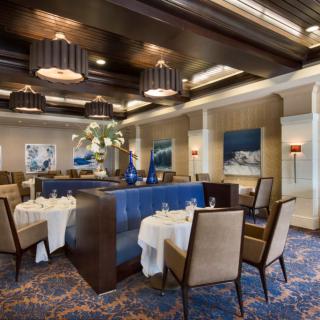 An elegant restaurant interior with neatly arranged tables and sophisticated lighting.