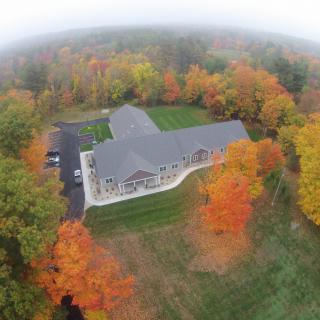 An aerial view of a building surrounded by vibrant autumn foliage.