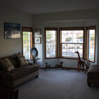 A cozy living room with sofas, large windows, and decorative elements including a giraffe sculpture.