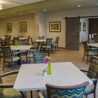 A cozy dining area featuring neatly arranged tables and chairs with modern decor.