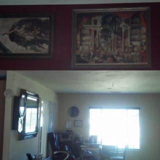 A cozy living room with decorative paintings and a window allowing natural light to fill the space.