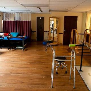 A spacious physical therapy room equipped with a walker and exercise equipment.