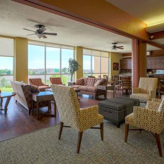 A spacious living room with multiple seating areas, large windows, and ample natural light.
