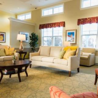 A cozy living room with comfortable sofas, a coffee table, and ample natural light.