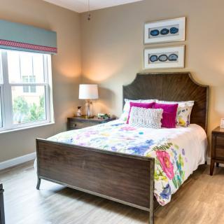 A cozy and colorful bedroom with a wooden bed, vibrant bedding, and elegant decor.