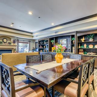 A beautifully designed dining room featuring a large table with ornate chairs, surrounded by bookshelves and elegant decor.
