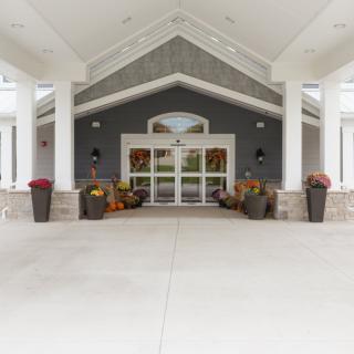 A symmetrical building entrance with large columns and planters.