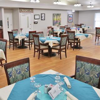 A neatly arranged dining area with tables and chairs, set up for service.