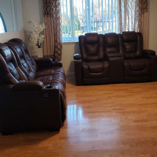 A living room with leather sofas and a hardwood floor.