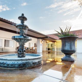 A beautifully designed outdoor space featuring a classic fountain and a decorative planter.