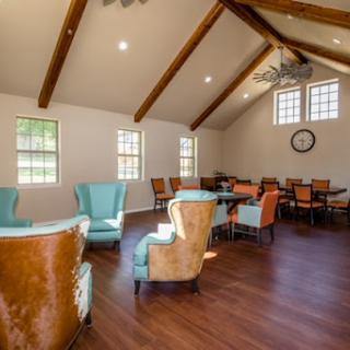 A spacious and inviting community lounge featuring wooden beams and comfortable seating.