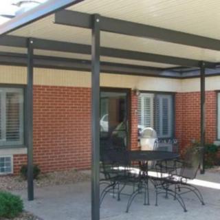 Outdoor patio with metal awning and seating area.