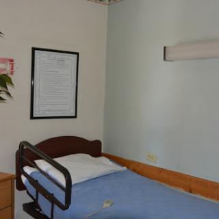 A view of a hospital room featuring a single bed and minimalist decor.