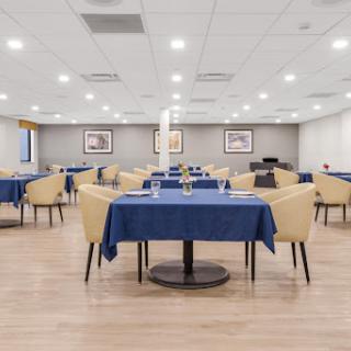 An organized dining area with blue tablecloths and modern furniture, ready for guests.